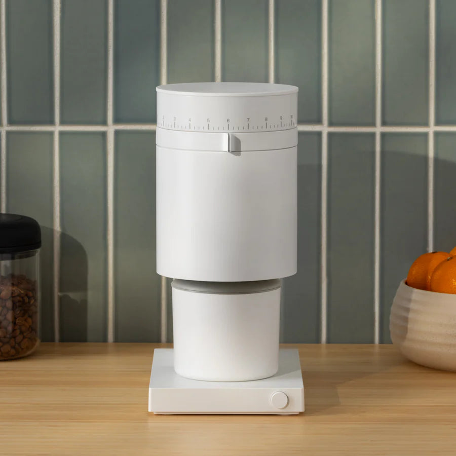 Fellow Opus Conical Burr Coffee Grinder in white, kitchen background